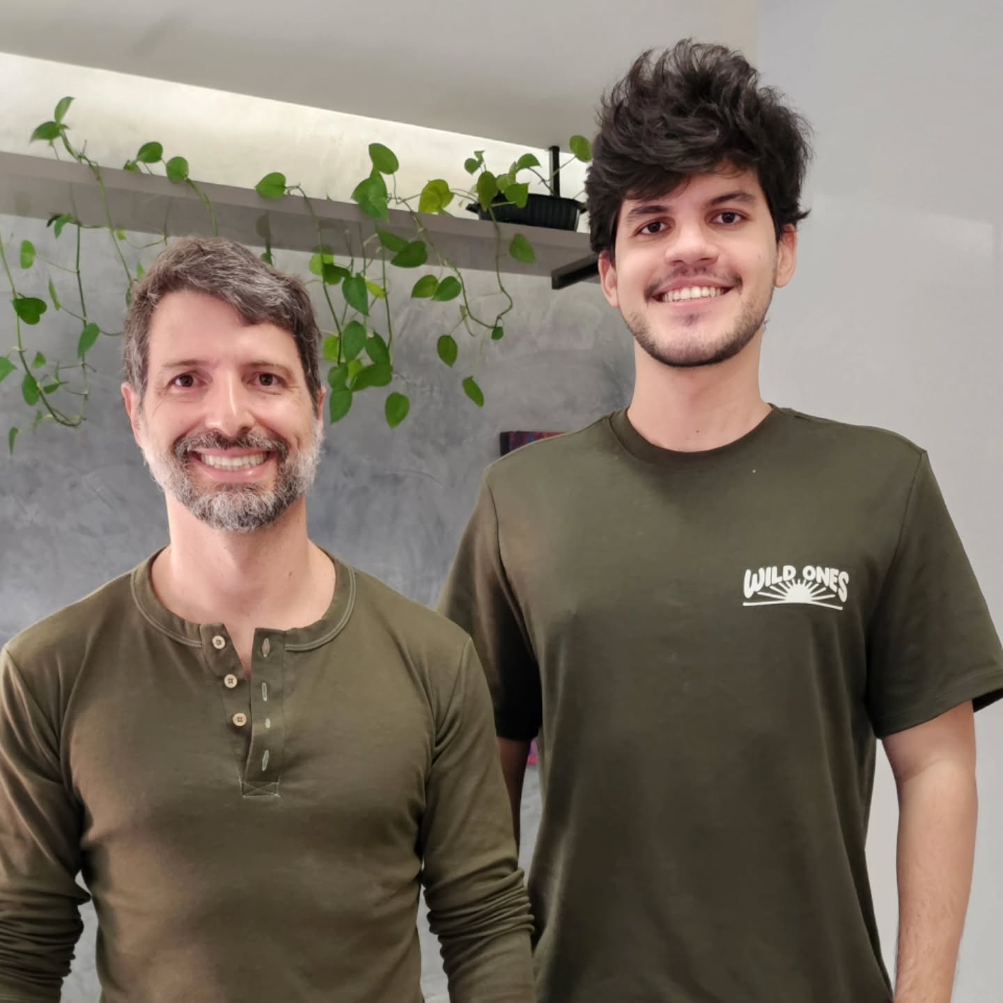 O Dr. Luiz Fernando ao lado do paciente, que sorri já sem o aparelho